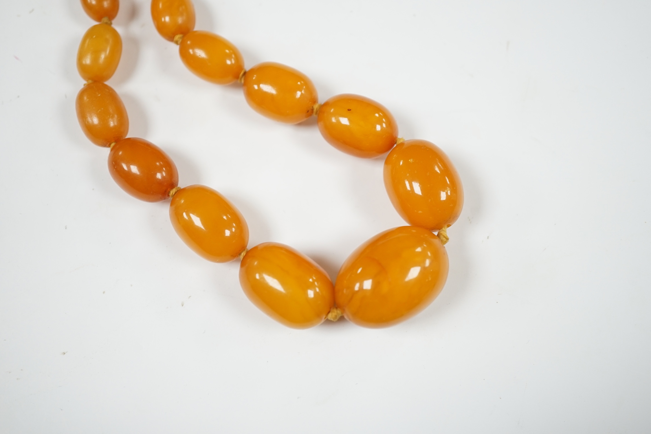 A single strand graduated oval amber bead necklace, 44cm, string broken, gross weight 39 grams. Condition - poor